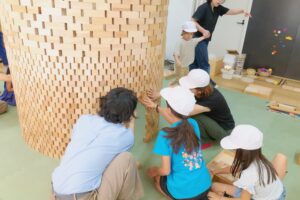 大型の積み木作品を協力して作る子どもたち