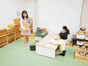 積み木遊びを追えて、絵で解くさんすう教室どんぐり倶楽部の準部をする子ども達