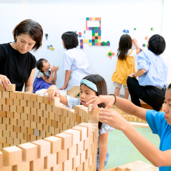 真剣に積み木で遊ぶ親子の画像